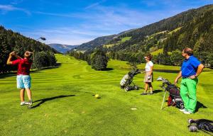 un gruppo di persone che giocano a golf su un campo da golf di Haus Alpentraum a Patergassen