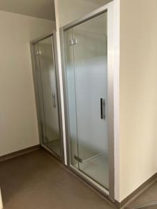 a glass shower in a room with a wall at O'Cottage suite Familiale in Annonay