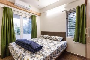 una camera con letto e finestra con tende verdi di SPLENDID SHUBHAM SERVICED APARTMENTS a Bangalore