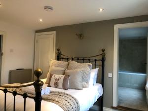 a bedroom with a bed with white sheets and pillows at The White Hart Inn in Ingatestone