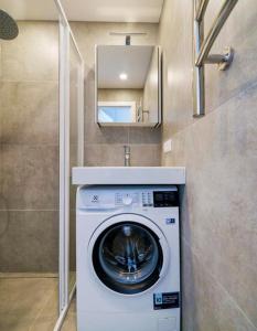 a washer and dryer in a small bathroom at Stylish Studio in Central Vilnius in Vilnius