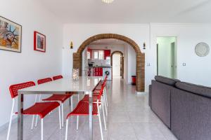 uma cozinha e sala de jantar com mesa e cadeiras vermelhas em 11 House in front of the sea em Mijas Costa