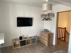 a living room with a flat screen tv on a wall at Superbe maison Tout Confort Parking Netflix 