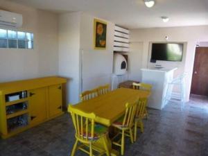 a kitchen with a wooden table and yellow chairs at Casa frente al mar Violeta, 5 personas un paraíso divino!!! in Punta del Este
