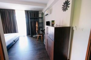 a bedroom with a bed and a dresser in a room at Wealth Boutique Hotel Chiang Mai in Chiang Mai