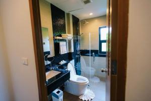 a bathroom with a toilet and a sink and a shower at Wealth Boutique Hotel Chiang Mai in Chiang Mai