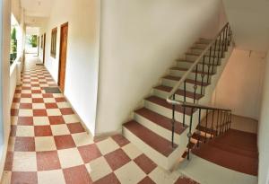 een trap in een gebouw met een geruite vloer bij Dwarka Residency in Mahabalipuram