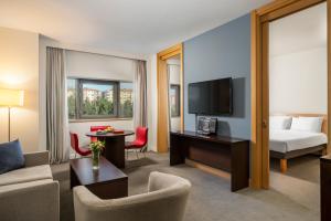 カイセリにあるノボテル カイセリのベッドとリビングルームが備わるホテルルームです。