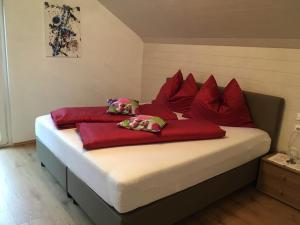 a bed with red pillows on it in a room at Ferienwohnung Kohlweis in Döbriach