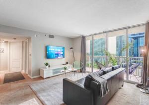a living room with a couch and a tv at Attractive 2/2 Condo In Brickell With Pool in Miami