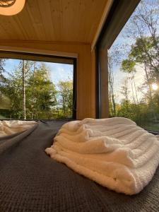 a blanket laying on the floor of a room with a window at Homnest Morvand'Ailes - Cocon immersif en Morvan in Saulieu