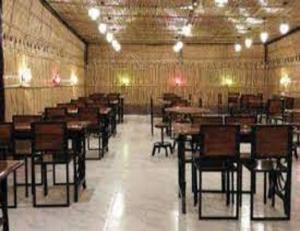 ein großes leeres Zimmer mit Tischen und Stühlen in der Unterkunft Hotel Shri Ram Residency, Sonipat, Haryana in Sonīpat
