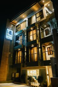 a building with a lit up sign in front of it at El Bien Hotel Tagaytay in Tagaytay