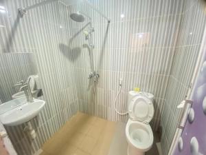 ein Bad mit einer Dusche, einem WC und einem Waschbecken in der Unterkunft Villa Matano Sorowako Redpartner in Saroako