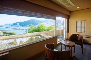 Zimmer mit einem großen Fenster mit Aussicht in der Unterkunft 熱海の隠れ里 in Atami