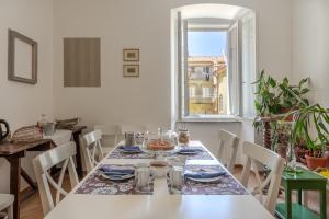 a dining room with a table and chairs and a window at Città del Capo in Trieste