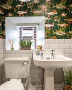 a bathroom with a toilet and a sink and a mirror at Luxury Cottage with Mountain View’s in Cononbridge