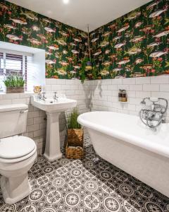 a bathroom with a tub and a toilet and a sink at Luxury Cottage with Mountain View’s in Cononbridge +19 photos