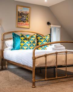 a bedroom with a bed with blue and yellow pillows at Luxury Cottage with Mountain View’s in Cononbridge