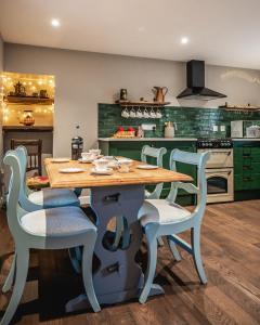a kitchen with a wooden table and chairs at Luxury Cottage with Mountain View’s in Cononbridge