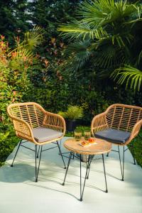 two wicker chairs and a table on a patio at Casa N in Arona
