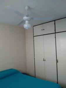 1 dormitorio con armarios blancos y ventilador de techo en Cielo Patagónico en Trelew