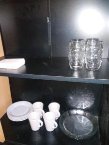 un mostrador negro con vasos y tazas en un estante en Cielo Patagónico en Trelew