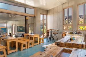 Großes Zimmer mit Holztischen und Fenstern in der Unterkunft Desert Estate Carmey Avdat in Midreshet Ben Gurion