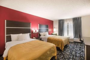 ein Hotelzimmer mit 2 Betten und einer roten Wand in der Unterkunft Quality Inn Northlake in Tucker