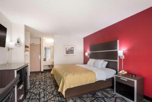 ein Hotelzimmer mit einem Bett und einer roten Wand in der Unterkunft Quality Inn Northlake in Tucker