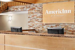 um lobby de uma pousada americana com uma parede de tijolos em AmericInn by Wyndham Roseau em Roseau