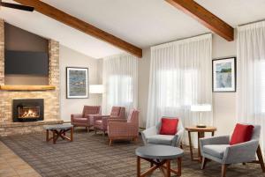 a living room with chairs and a fireplace at AmericInn by Wyndham Roseau in Roseau