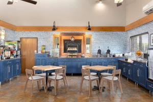 a kitchen with blue cabinets and wooden tables at AmericInn by Wyndham Roseau in Roseau