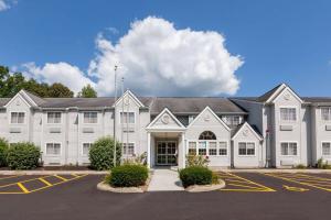 a large white building with a parking lot at Microtel Inn & Suites by Wyndham Sunbury - Columbus North in Sunbury