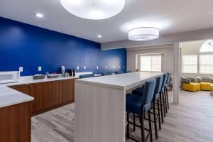 una cocina con una barra con paredes y sillas azules en Microtel Inn & Suites by Wyndham Sunbury - Columbus North, en Sunbury