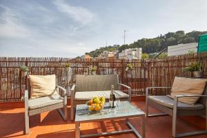 un balcón con 2 sillas y una mesa con un bol de fruta en BBarcelona El Carmel Apartment with terrace, en Barcelona