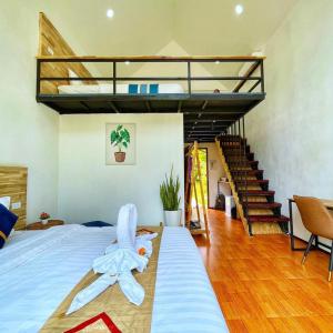 a bedroom with a bed and a loft with a staircase at Vangvieng Angsavanh Resort in Vang Vieng