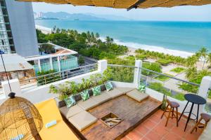 uma varanda com um sofá e vista para a praia em Azura Gold Hotel & Apartment em Nha Trang