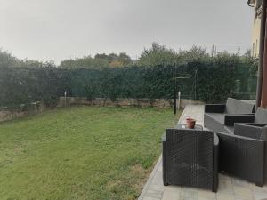 een patio met stoelen en een grasveld bij Casa Mia in Verona