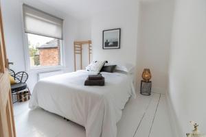 a white bedroom with a white bed and a window at Luxe Garden House for 6 in Central Exeter in Exeter