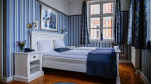 a bedroom with a bed with blue and white stripes at Hotel Ærø in Svendborg