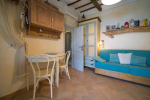 a living room with a blue couch and a table at Agave direclty on the beach - Goelba in Portoferraio