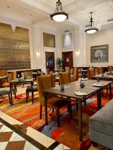- un restaurant avec des tables et des chaises dans une salle dans l'établissement Taj HotelApart, Taj Hotel Cape Town, au Cap