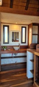 Un baño con lavabo y dos ventanas. en Cabañas 5 Sentidos, en Punta del Diablo