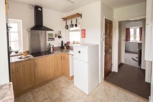 a kitchen with a white refrigerator in a room at Moorings in Fairbourne