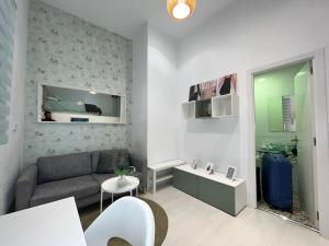 Elle comprend un petit salon doté d'un canapé et d'un lavabo. dans l'établissement Encantador Puente Segovia Caramuel, à Madrid