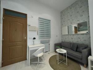 a small living room with a couch and a table at Encantador Puente Segovia Caramuel in Madrid