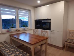 een keuken met een houten tafel en een koelkast bij Haus Amann in Prackenbach