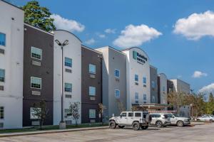 dos camiones estacionados en un estacionamiento frente a un edificio en MainStay Suites Denham Springs - Baton Rouge East, en Denham Springs