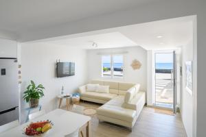 a white living room with a couch and a table at Casa Roman in Punta Mujeres